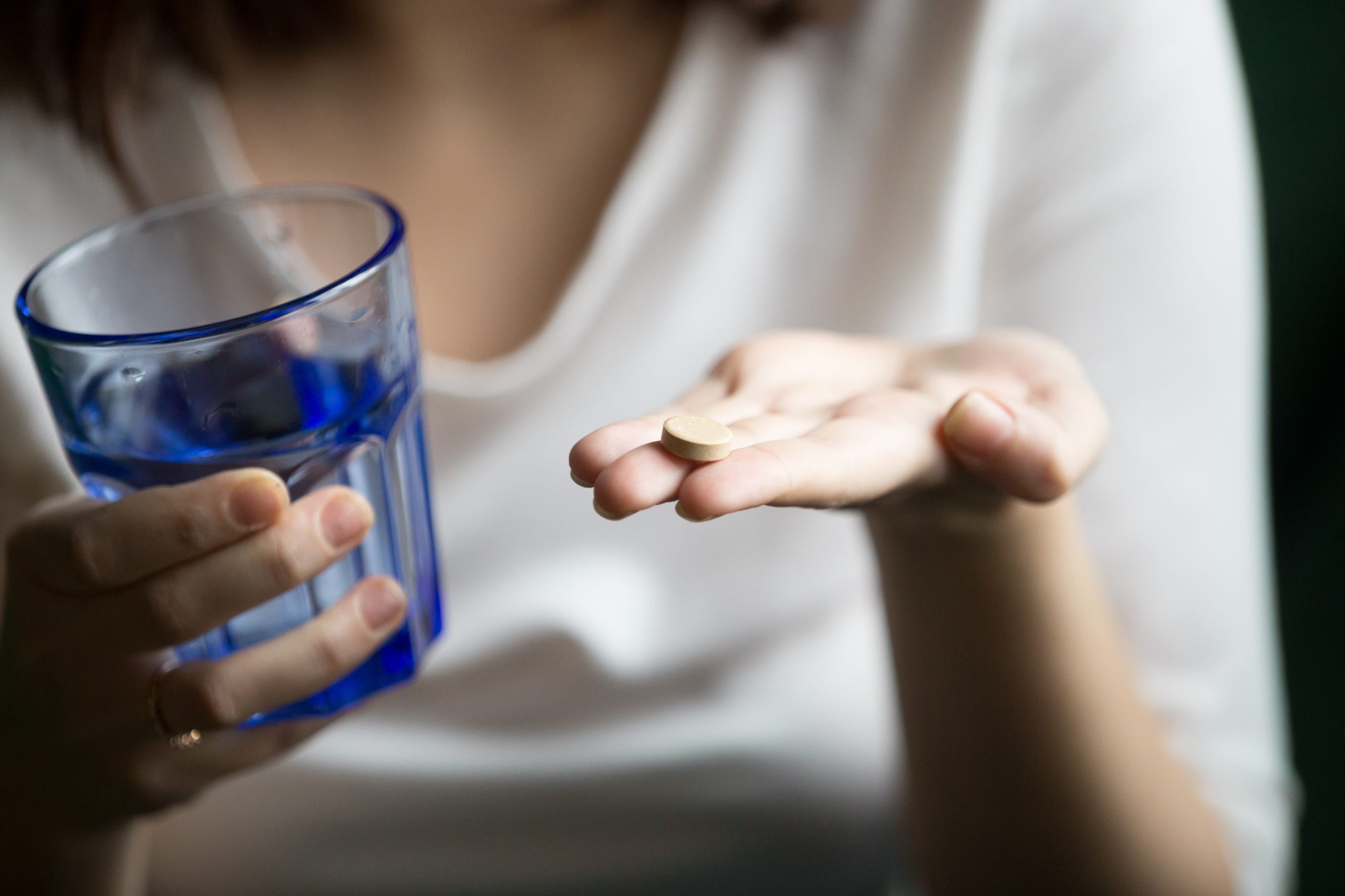 femininas maos segurando pilula e vidro agua vista closeup scaled - Abuso de medicamentos psicotrópicos: entenda os riscos